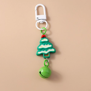 Close-up of green Christmas tree keychain with a matching bell and white snow detail
