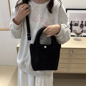 Minimalist black corduroy bucket bag for women with adjustable strap and top handle