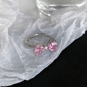 Detail of pink heart-shaped bow ring with cubic zirconia and adjustable silver band