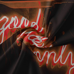 Detail of bohemian tapestry fabric with Good Vibes Only neon orange text print