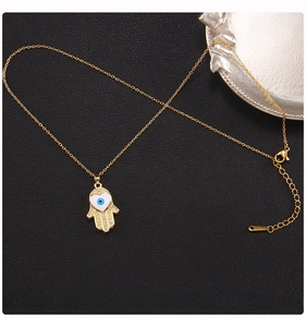 Detail of gold Hamsa Hand pendant with blue Evil Eye and 45cm titanium steel chain