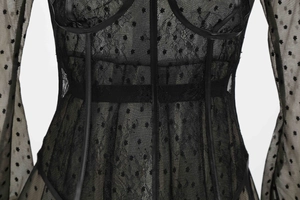 Detail of black mesh lace dress with flocked polka dots and high-quality leather trim