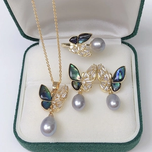 Golden butterfly jewelry set with grey pearls and shell inlay in a green velvet box