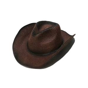 Close-up of a vintage brown straw cowboy hat with burnt gradient brim and rustic texture