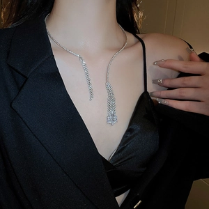 Close-up of elegant silver tassel necklace with rhinestones on a woman's collarbone