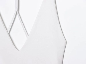 Detail of white halter neck mini dress showing V-neckline and cross strap stitching
