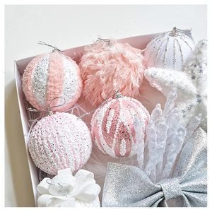 Detailed close-up of pink and white plush Christmas ornaments with sequins and knit texture