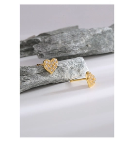 Macro shot of gold S925 silver heart stud earrings with sparkling pave zircon stones
