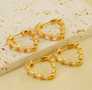 Detail of heart hoop earrings in 18K gold finish with pink and clear zircon stones