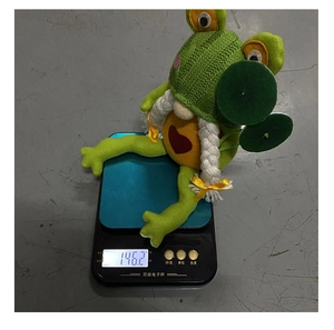 Misura del peso di una bambola gnomo rana in maglia verde con 146,2 once sulla bilancia