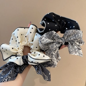 Détail de chouchou en tissu à pois et motif paisley avec de longs rubans fluides