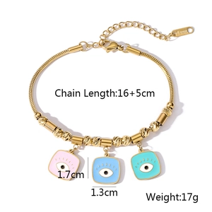 Macro shot of gold stainless steel bracelet with three colorful enamel evil eye charms