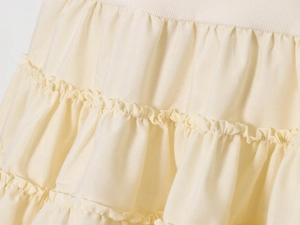 Detailed macro view of layered cream ruffled fabric and texture on a tiered dress