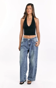 Full view of blue vintage washed wide-leg jeans with a black halter neck cross top