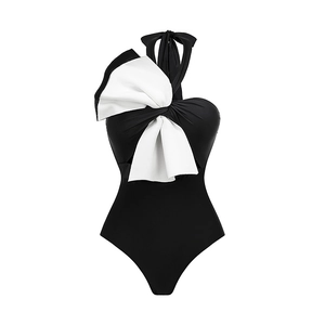 Detail of a large white bow with black edges on a black one-piece halter swimsuit