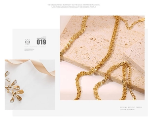 Detailed close-up of golden chunky woven chain necklace with lobster clasp and extender