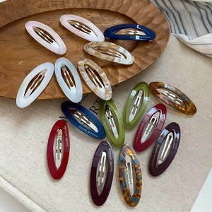 Detail of oval acetate hair clips with metal spring in various marble and candy colors