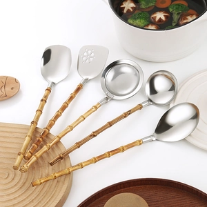 5-piece stainless steel kitchen tool set with natural bamboo handles on a wooden board