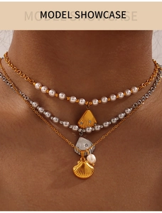 Detail of layered gold and silver shell pendants with freshwater pearls on model