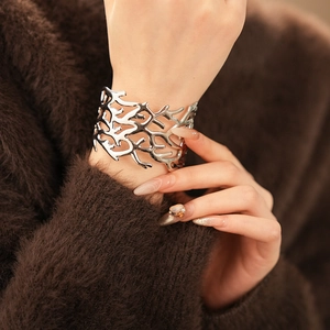 Silver hollow coral texture wide cuff bracelet shown on model with branch-like details