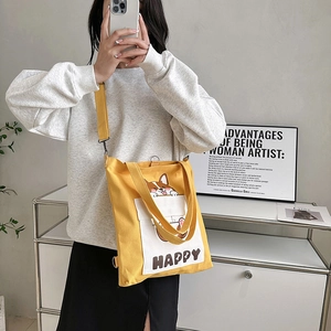 Yellow canvas crossbody bag with Corgi print and adjustable strap in a modern setting