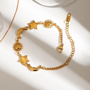 18K gold-plated stainless steel bracelet featuring sun, moon and star charms in soft natural light