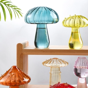 Colorful mushroom glass vases with varied textures and sizes on a wooden stand