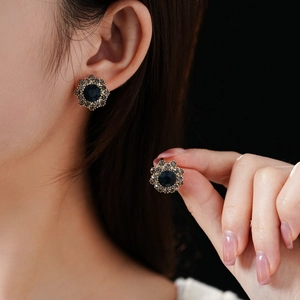 Gros plan sur des boucles d'oreilles fleur vintage avec pierre bleue et cristaux