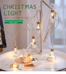 Detail of Christmas wishing bottle string lights with miniature snowy trees and warm LED glow