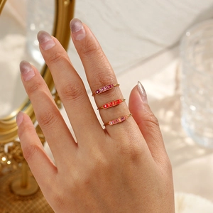 Detail of adjustable 18K gold plated mama rings with pink enamel and small crystals