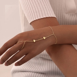 Detail view of double-layer gold heart hand chain on hand for a chic, minimalist look
