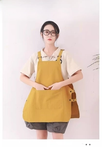 Detail of water-resistant work apron with large front pockets and adjustable side buttons