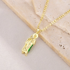 Detail of golden St. Jude pendant with green enamel accents on a Figaro chain