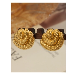 Macro detail of 18K gold plated fan-shaped earrings with unique hammered texture finish