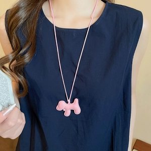 Détail d'un pendentif chiot rose mignon sur un collier à cordon réglable élégant
