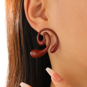 Close-up of elegant wine red spiral statement earrings on model for festive occasions