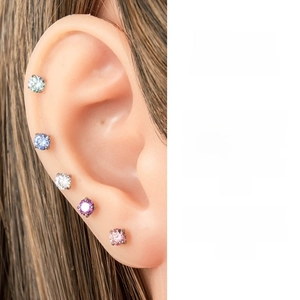 Detail view of 5-piece multi-colored 4mm zircon stud earrings on a silicone ear model