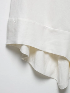 Close-up of high-quality white cotton and linen fabric with detailed stitching and texture