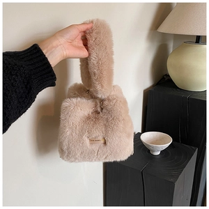 Close-up of pink faux fur bucket bag with short handle and 'love every' label detail