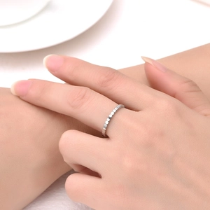 Macro shot of a faceted silver stainless steel eternity ring on a model's index finger