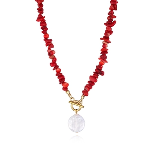 Close-up of red gravel bead necklace with white baroque pearl pendant and gold OT buckle