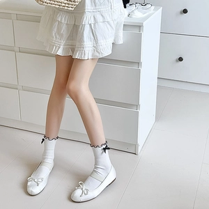 White JK style lolita socks with black lace edge and bows paired with Mary Jane shoes
