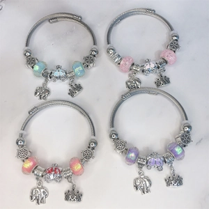Detail of beaded bracelets with elephant, crown, and pumpkin coach charms for girls