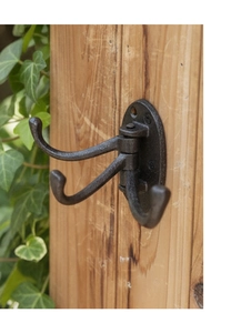 Close-up of vintage cast iron triple swivel wall hook with rustic textured finish