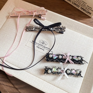 Detailed shot of elegant bow hair clips with pearls and rhinestones on a beige fabric surface