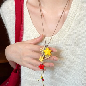 Detail of creative acrylic star and square pendant on a brown adjustable cord necklace