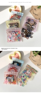Detail shot of assorted colorful elastic hair ties in cute cartoon clear packaging