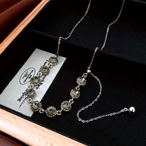 Detail of vintage gold necklace featuring grey crystal units and sparkling rhinestones