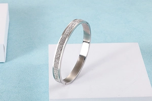 Vue détaillée du bracelet en acier argenté avec pavé de cristaux brillants sur bloc blanc