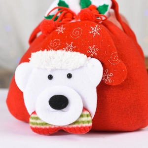 Detail of Christmas gift bag showing red felt texture and 3D plush bear with festive bow